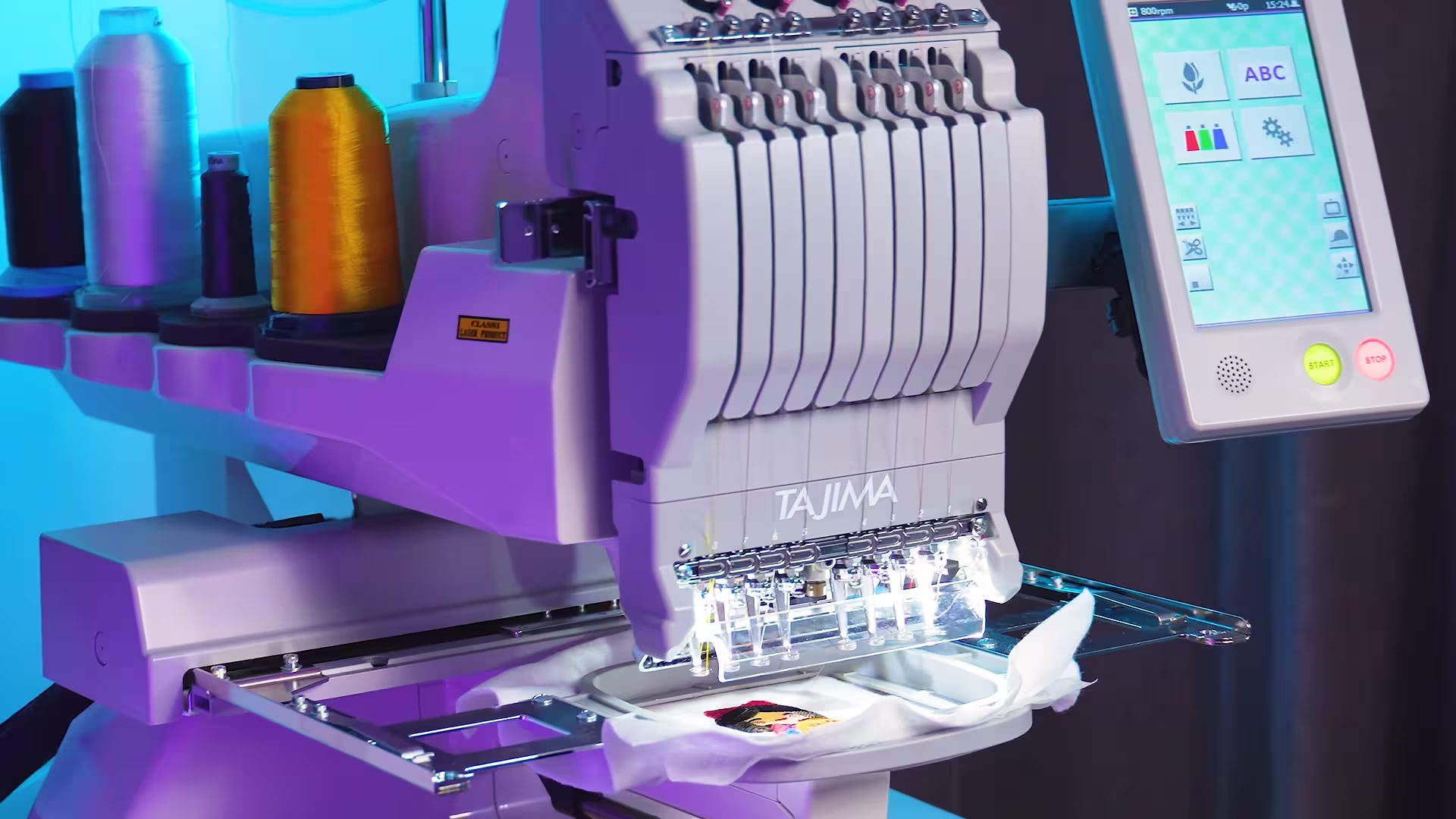 Close-up of high-density embroidery stitching a custom sports patch using industrial Tajima equipment.