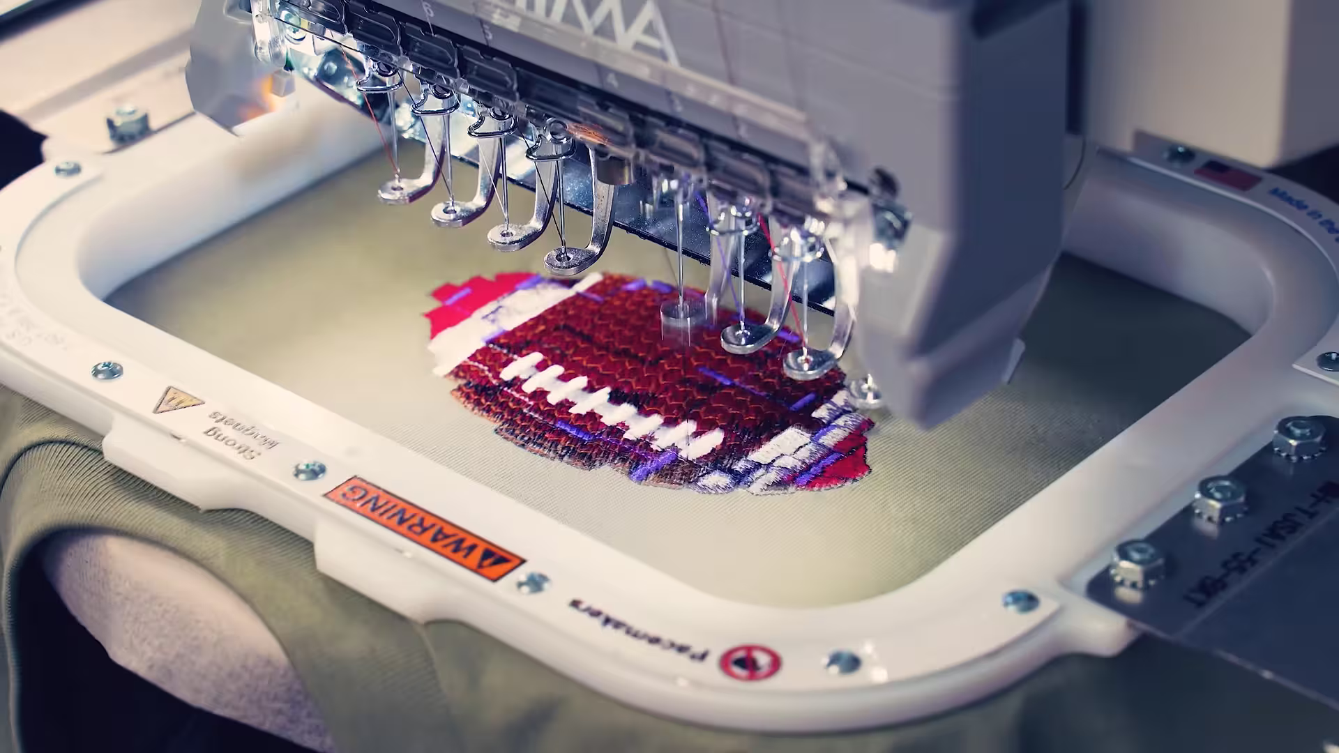 Detailed embroidery process using 40-weight Madeira thread on a Tajima machine at our Houston shop.