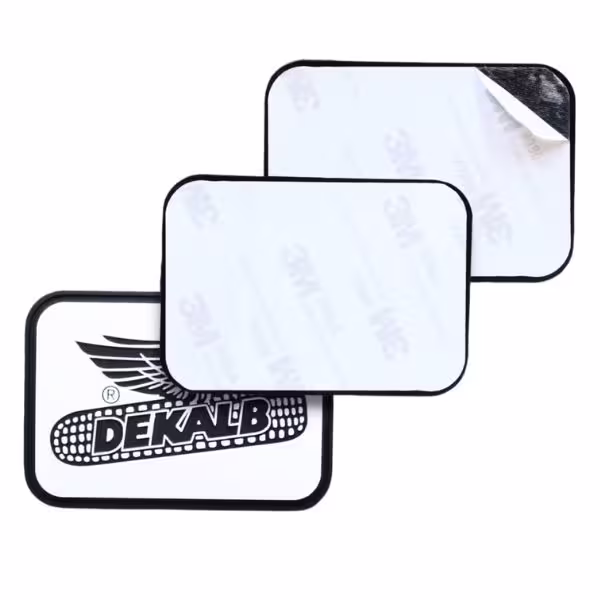 A rectangular custom patch showing a paper peel-and-stick adhesive backing being peeled away.