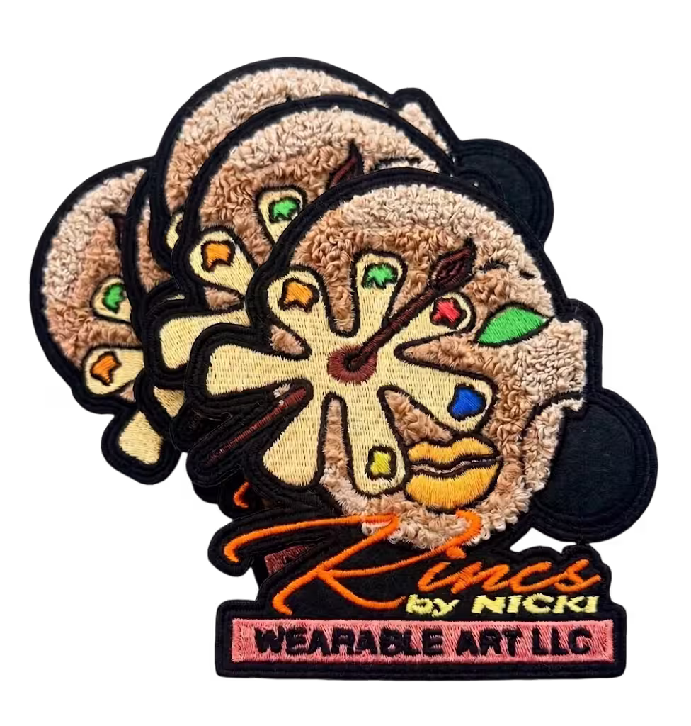 Custom patches combining fuzzy chenille and embroidered letters, featuring an artistic face design and 'Rings by Nicki' text.