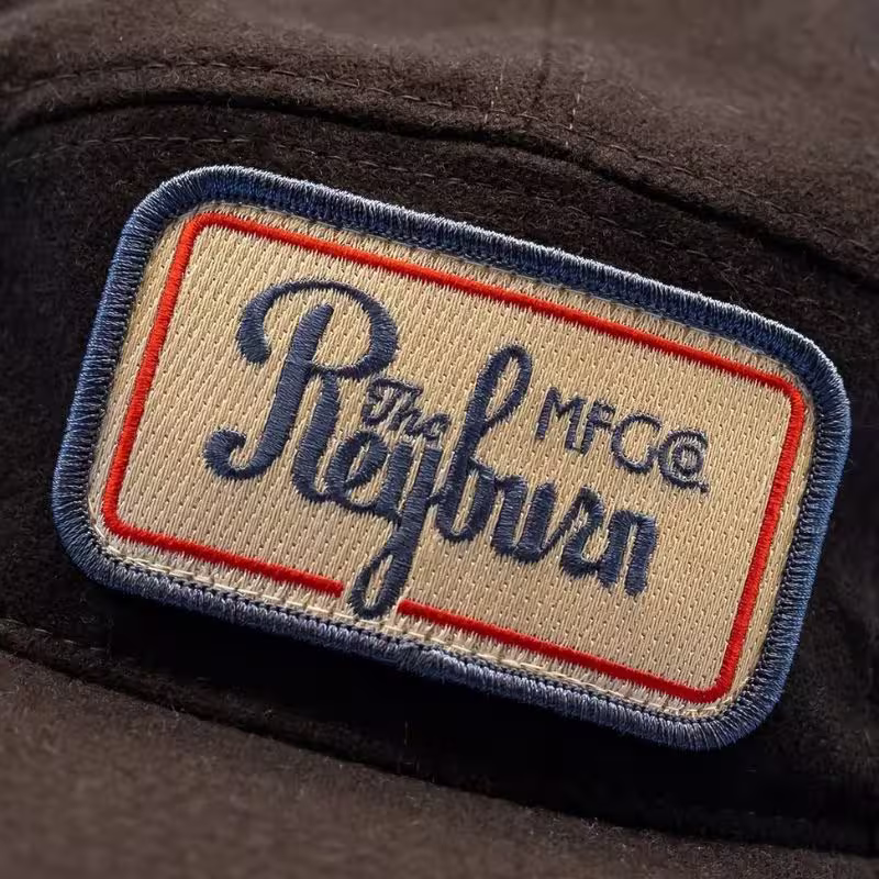 Heavyweight embroidered patch on wool showing tight thread tension from Tajima machines.