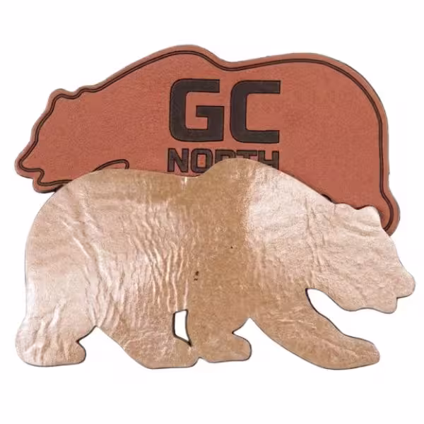 A bear-shaped custom patch displaying a shiny, heat-activated iron-on adhesive backing.