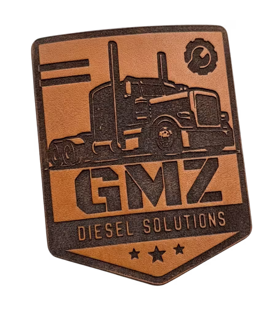 Shield-shaped engraved leather patch with a semi-truck and diesel solutions branding.