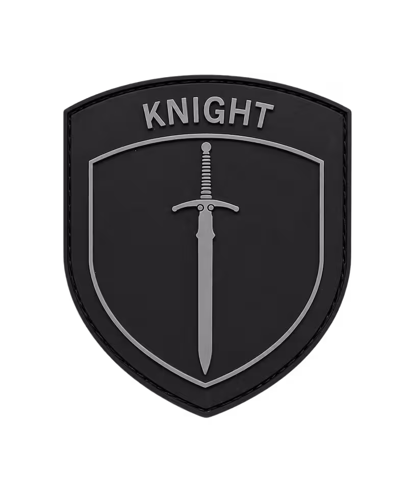 Shield-shaped black 2D PVC patch featuring a minimalist grey sword and the word KNIGHT at the top.