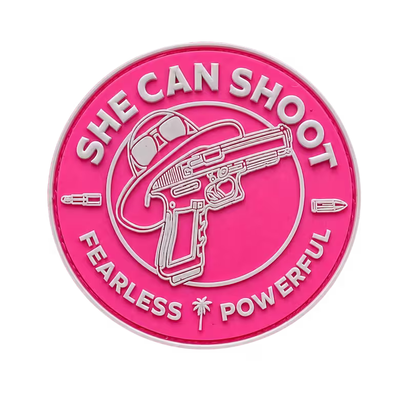 Bright pink 3D PVC patch featuring a handgun hat lipstick and raised She Can Shoot text.