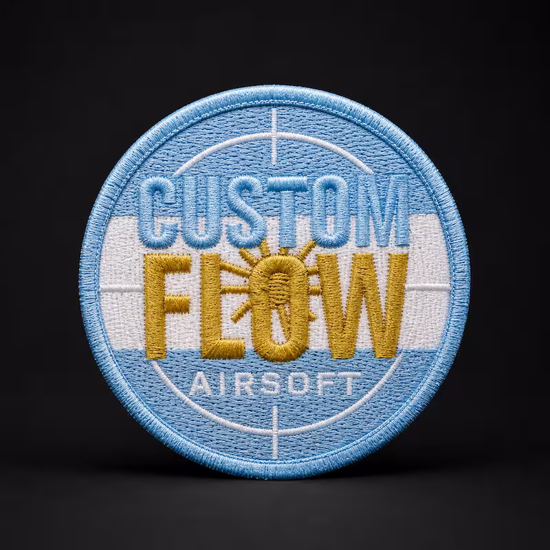 Circular blue and white embroidered patch for Custom Flow Airsoft featuring a yellow sun and crosshair overlay.