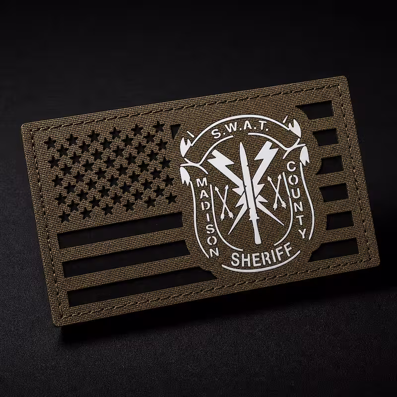Olive green laser-cut tactical patch featuring US flag cutouts and a white Madison County Sheriff SWAT insignia.